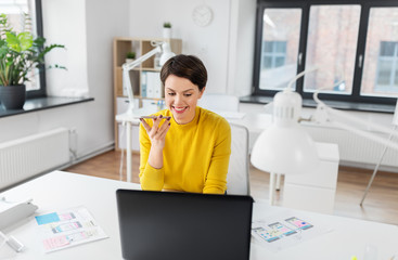 business, technology and ui design concept - smiling creative woman with laptop computer and user interface templates using voice command recorder on smartphone at office