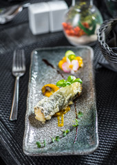 Japanese fried sushi rolls with salmon, tuna and shrimps on dark background.
