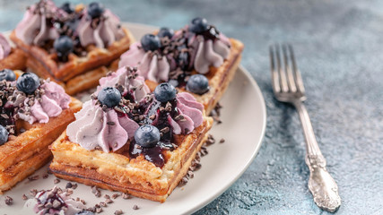 Close-Up Homemade Viennese waffles with cream, jam, blueberry and mint leaves. Delicious Dessert