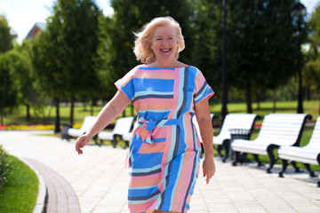 Happy elderly woman on the background of summer park
