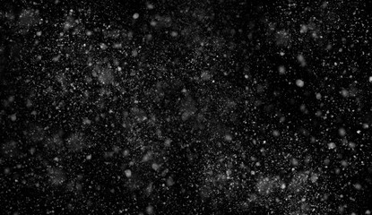 First falling snow bokeh texture on black background. Winter texture.