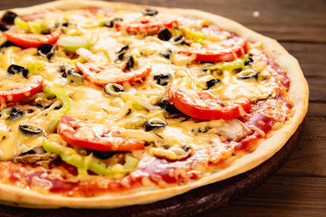 Appetizing pizza on a wooden background