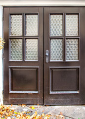 Glass window of an old door laid by glass bottles bottom