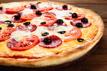 Appetizing pizza on a wooden background
