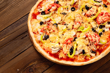 Appetizing pizza on a wooden background