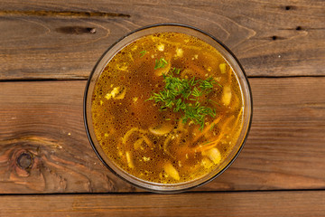 Bouillon quail egg in a transparent round plate on a wooden background