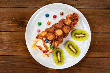 Ice cream ice cream in a waffle cone with sweets and fruit syrup