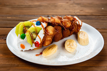 Ice cream ice cream in a waffle cone with sweets and fruit syrup