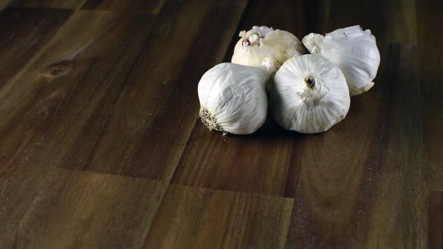 Garlic on the dark rotating wooden table. Copy space.