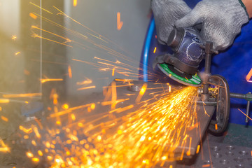 close up hand worker and electric wheel grinding machine and spark light