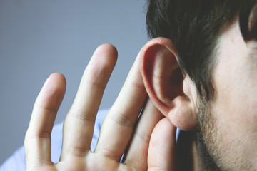 Businessman trying to hear a gossip