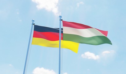 Hungary and Germany, two flags waving against blue sky. 3d image