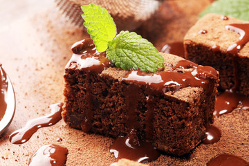 Brownie dessert. Cake chocolate brownies on wooden background with mint.