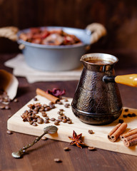 Composition with vintage metal turk for coffee with coffee beans and spices: cinnamon and anise. Served on a white wooden board. Morning routine of good day start. Cozy home inspiration, mood
