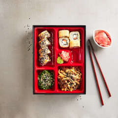 Japanese Bento Box with Sushi Rolls, Salad and Main Course Top View