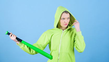 Woman play baseball game or going to beat someone. Girl hooded jacket hold baseball bat blue background. Woman in baseball sport. Baseball female player concept. Feeling power. She is dangerous