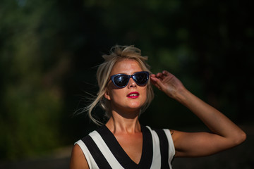 beautiful blonde woman in the autumn forest at sunset