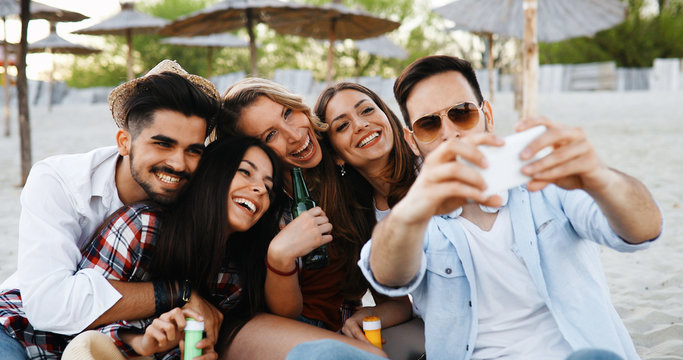 Group of young friends laughing and drinking beer
