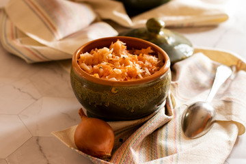 sauerkraut in a glossy cup on a linen napkin and a light background