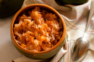 sauerkraut in a glossy cup on a linen napkin and a light background