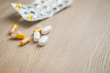 Fototapeta na wymiar Variation von verschiedene Pillen Blister und weiße Tabletten auf Holz Hintergrund mit Copy Space