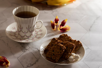 White cup of tea with blueberry cookies on a light background