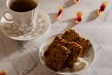 White cup of tea with blueberry cookies on a light background