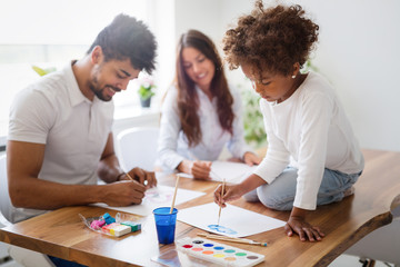 Mother and father drawing together with their child