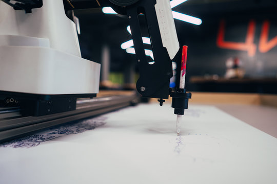Plotter draws a pen drawing on a sheet of white paper