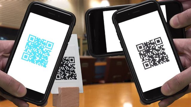 Scanning QR CODE look alike black and white pattern (CAN NOT SCAN THIS) to make a cashless payment via smartphone at the store.  Colorful QR CODE flashing on smartphone screen.