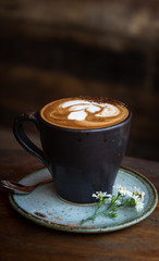 Portrait Shot of a Mocha Coffee made with Almond Milk and raw CoCoa Powder Grow In Indonesia for a Vegan Diet. Vegan Coffee, Vegan Mocha. Served on a wooden table with a blurred wooden background