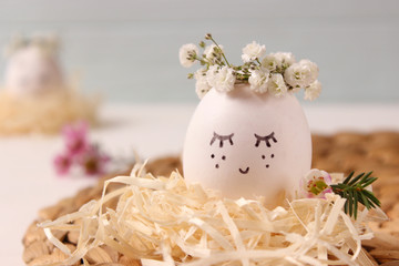  composition for Easter with a place to insert text. cute egg in a flower wreath and painted face.