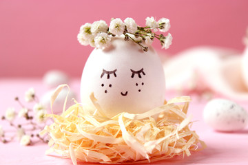  composition for Easter with a place to insert text. cute egg in a flower wreath and painted face.