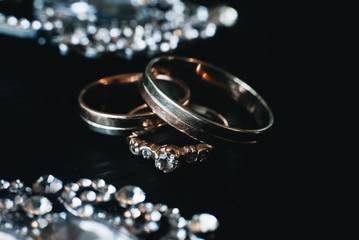 Wedding engagement rings on black background. Love concept.Selective focus. Photo with interesting highlights