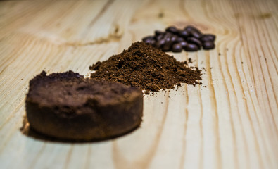 Three stages for preparation of coffee: grain, crushing and the pressed tablet. Wooden surface. Espresso. Work barista.