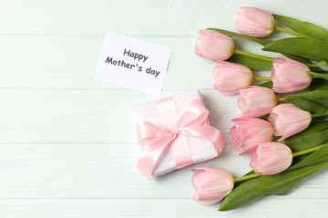  Beautiful composition for the Day of Mother on wooden background top view. Flowers, greeting card, gift.