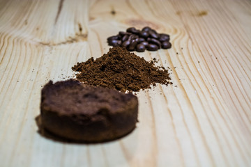 Three stages for preparation of coffee: grain, crushing and the pressed tablet. Wooden surface. Espresso. Work barista.