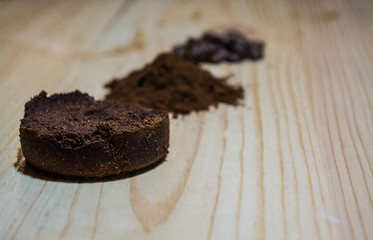 Three stages for preparation of coffee: grain, crushing and the pressed tablet. Wooden surface. Espresso. Work barista.