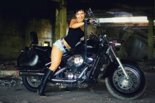 Strong independent , self-sufficient girl with male fascination on chopper motorcycle, international womens day concept