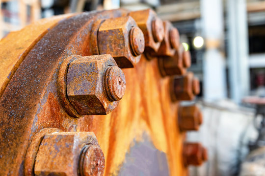 The cover of the old rusty heat exchanger covered with the same rusty bolts and nuts