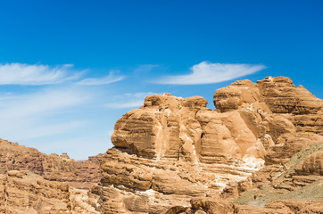 Fototapeta na wymiar high rocky mountains in the desert against the blue sky and white clouds in Egypt Dahab South Sinai