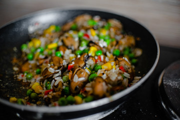 Fried frozen vegetable with rice and see food. Food remains in a black frying pan