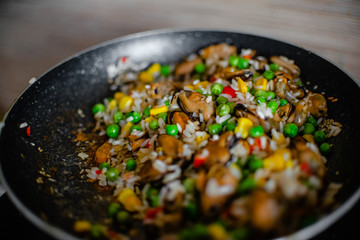 Fried frozen vegetable with rice and see food. Food remains in a black frying pan