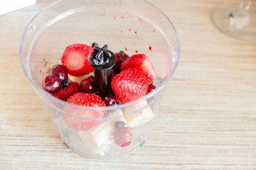 Ingredients for smoothie on wooden desk. Smoothies of strawberries ,blackberries,blueberries raspberry and cherries with yogurt.