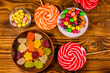 Different sweet candies on a wooden table. Top view