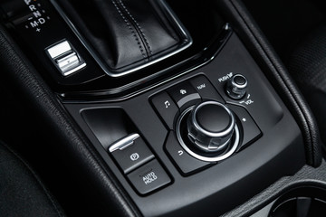Сlose-up of the car  black interior:  dashboard,  accelerator handle, parking systems, seats and other buttons.
