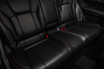 Сlose-up of the car  black interior:  black leather rear seats and seat belts .