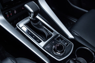 Fototapeta na wymiar Сlose-up of the car black interior: dashboard, accelerator handle, parking systems, seats and other buttons.
