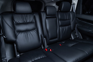 Сlose-up of the car  black interior:  black leather rear seats and seat belts .