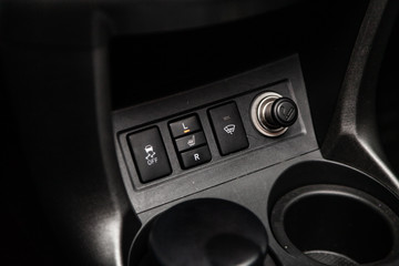 Сlose-up of the car  black interior:  seat heating buttons, 4wd buttons, parking systems and other buttons .